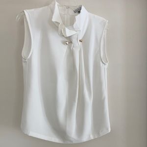 Cream sleeveless blouse with pearl pin